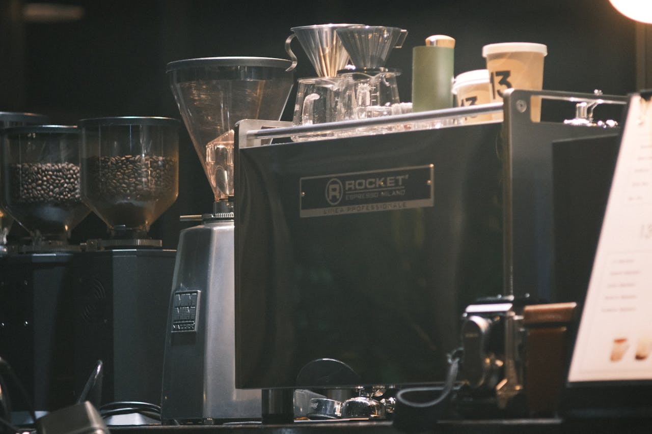 Close-up of an espresso machine in a cafe with coffee grinders and cups.