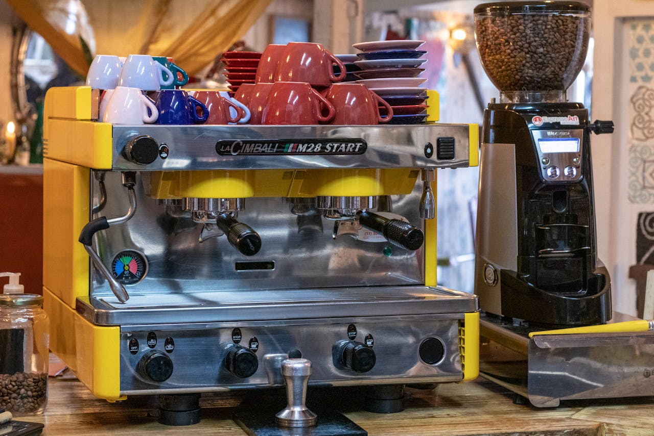 Espresso machine with colorful cups in cozy cafe setting, perfect for coffee lovers.